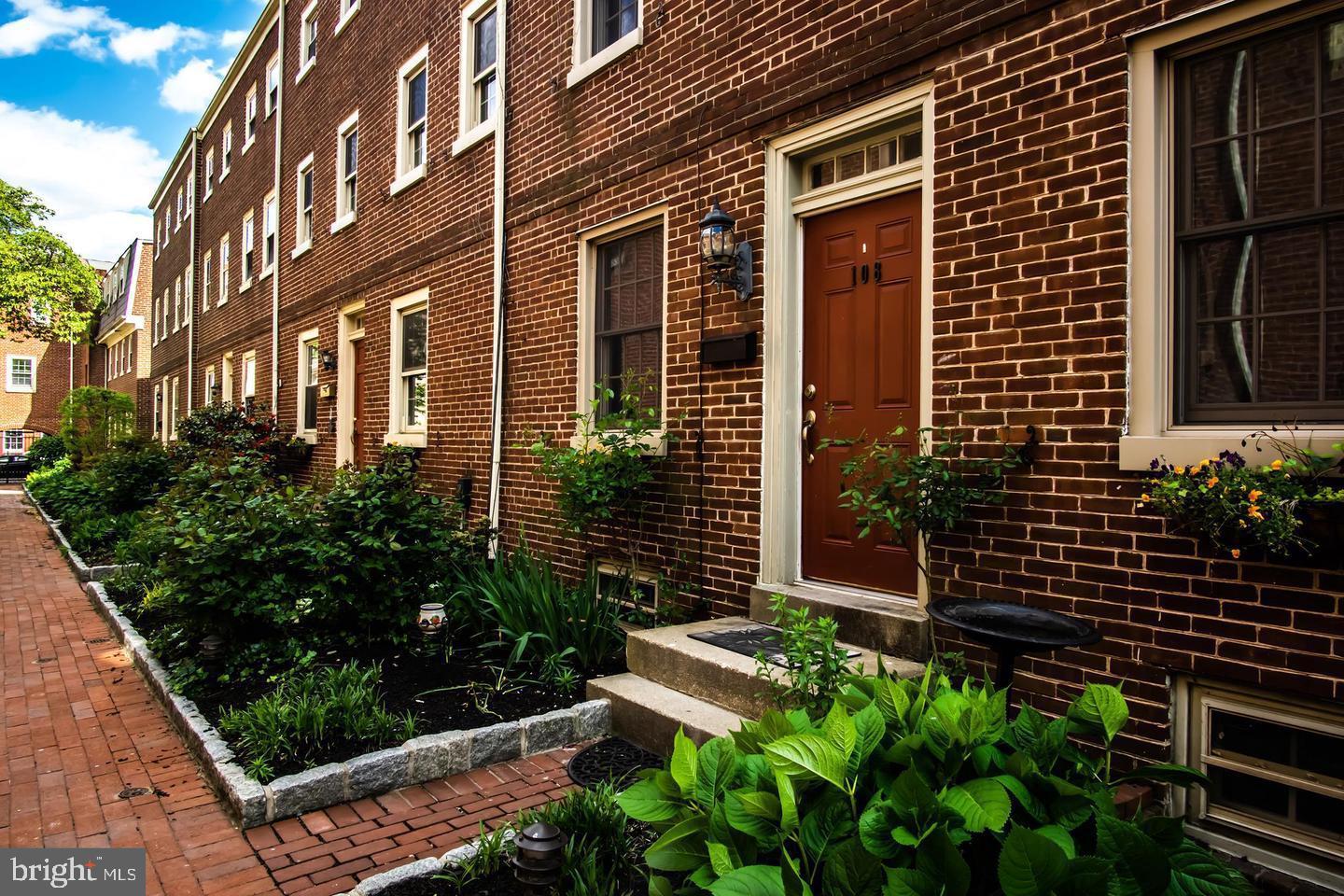 a view of a brick house with plants
