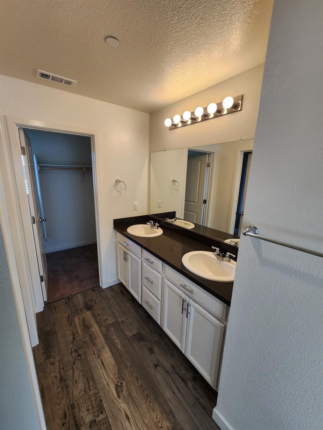 4384 Silver Cedar Lane Sacramento, CA 95834 - Photo 13 of 21 a bathroom with a double vanity sink and mirror