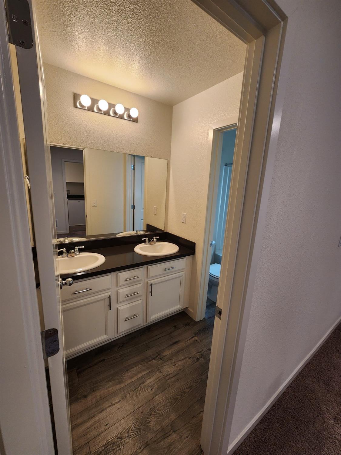 4384 Silver Cedar Lane Sacramento, CA 95834 - Photo 15 of 21 a large bathroom with a double vanity sink a mirror and a bathtub