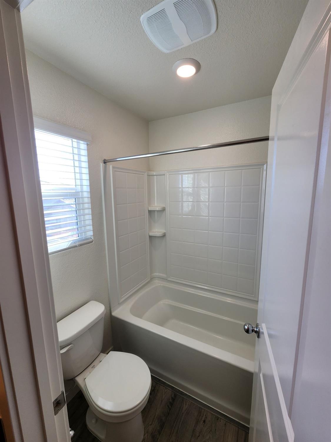 4384 Silver Cedar Lane Sacramento, CA 95834 - Photo 16 of 21 a bathroom with a toilet and a shower