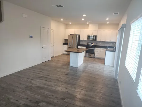 a open kitchen with white cabinets and white appliances