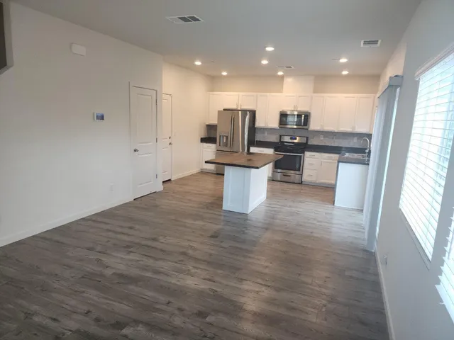 a open kitchen with white cabinets and white appliances