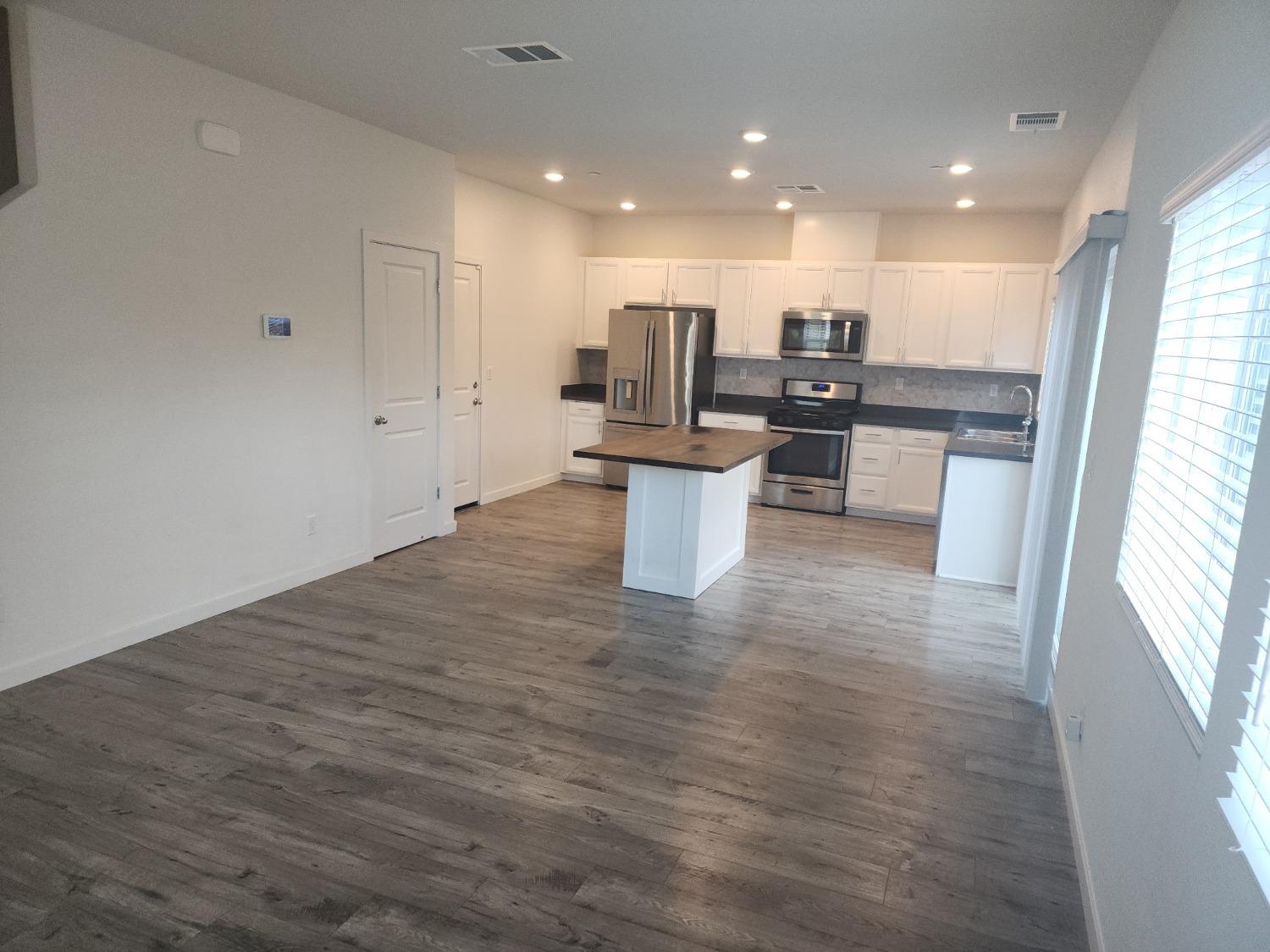 4384 Silver Cedar Lane Sacramento, CA 95834 - Photo 4 of 21 a open kitchen with white cabinets and white appliances