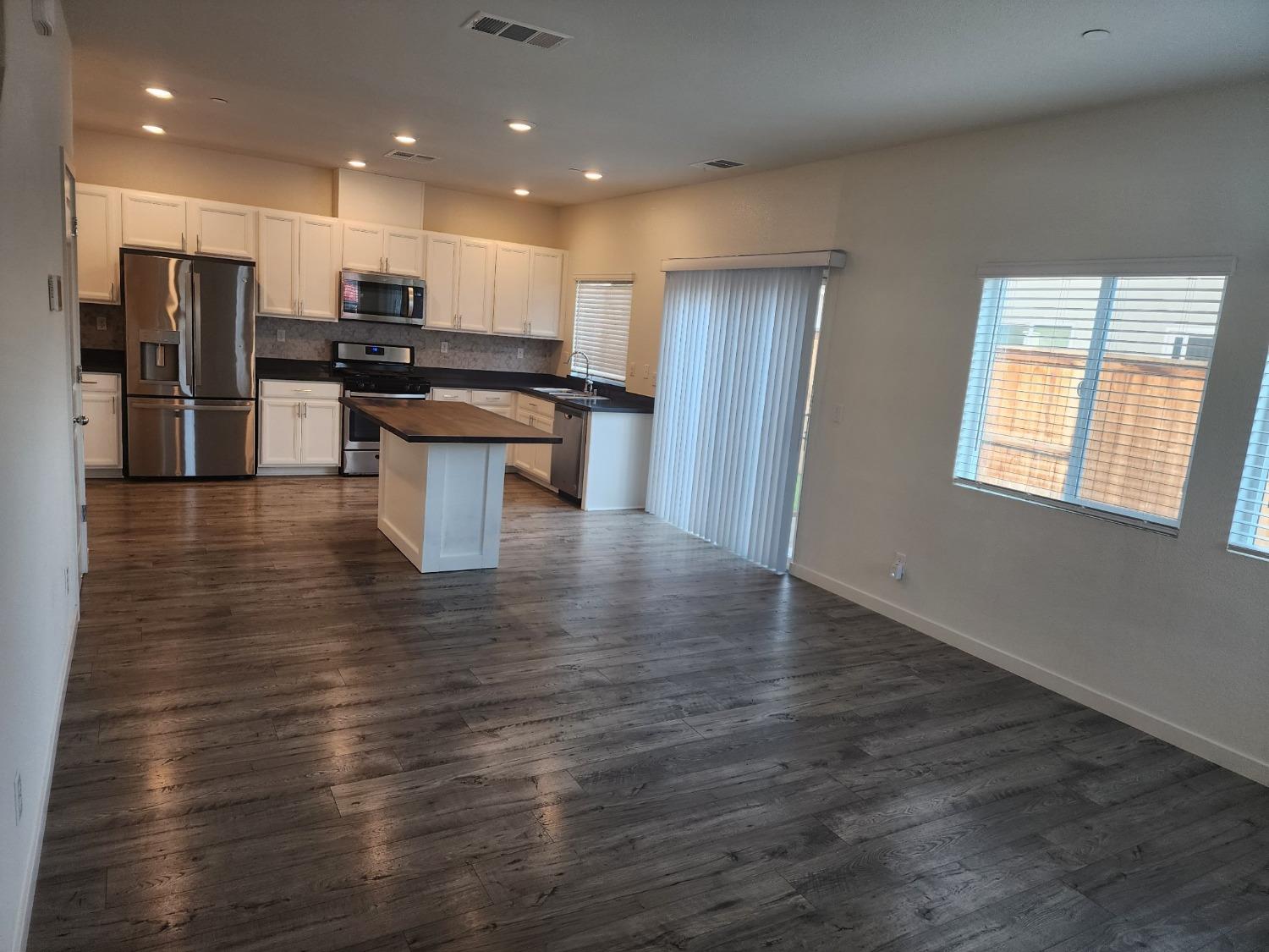 4384 Silver Cedar Lane Sacramento, CA 95834 - Photo 5 of 21 a kitchen with stainless steel appliances kitchen island granite countertop a stove and a refrigerator