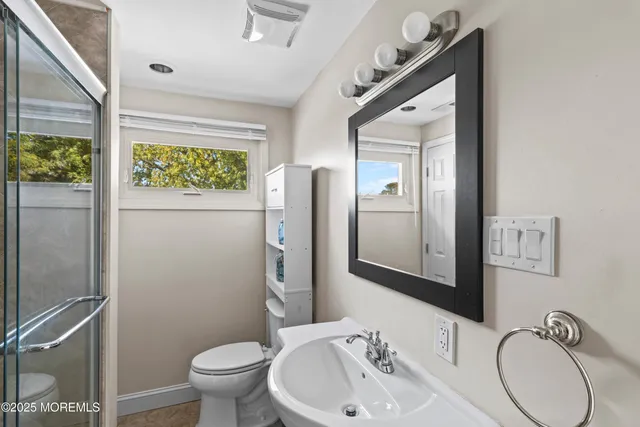 a bathroom with a toilet sink and mirror