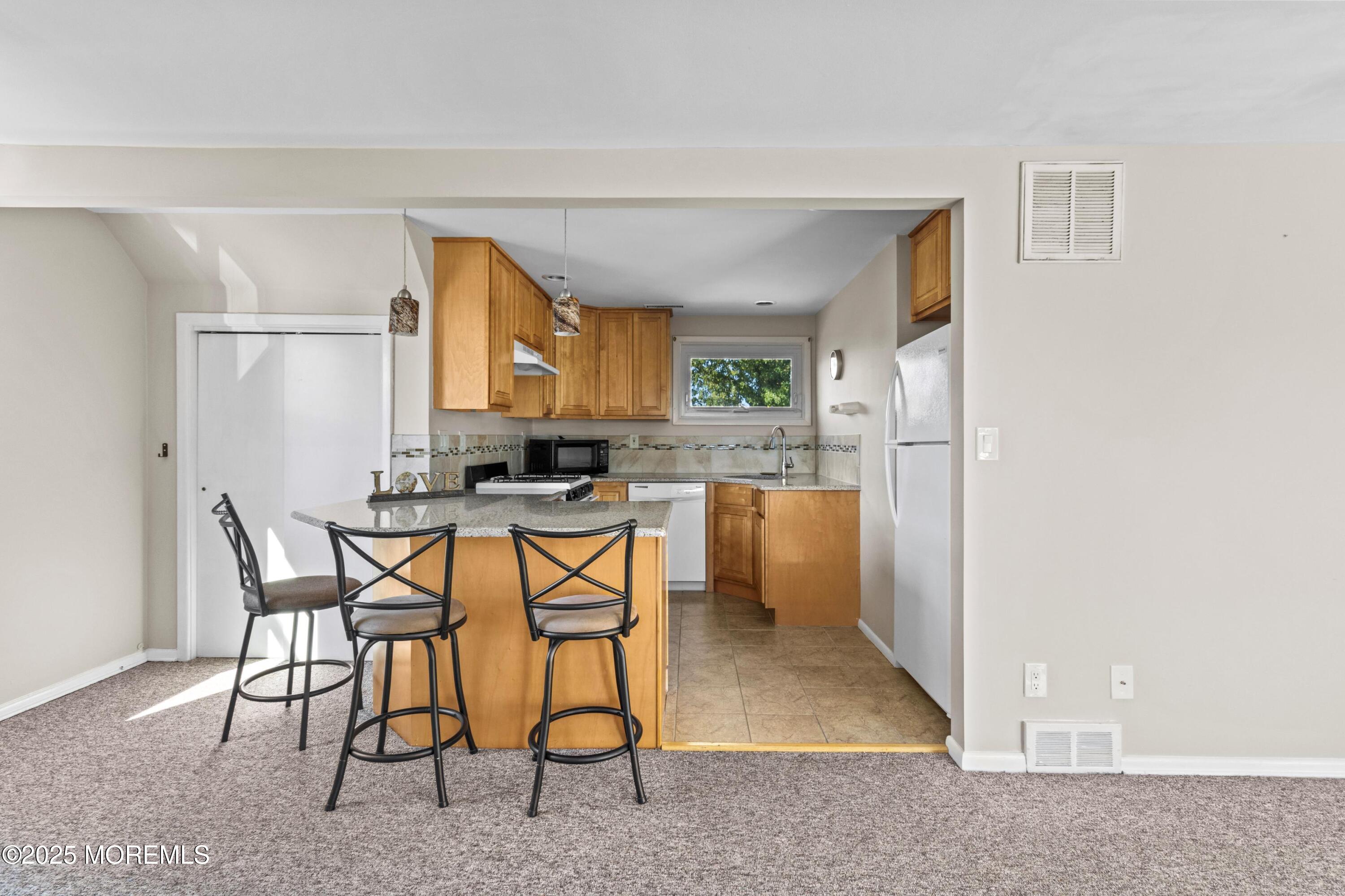 633 North Manetta Drive Point Pleasant, NJ 08742 - Photo 6 of 28 a kitchen with stainless steel appliances kitchen island granite countertop a refrigerator and a stove top oven