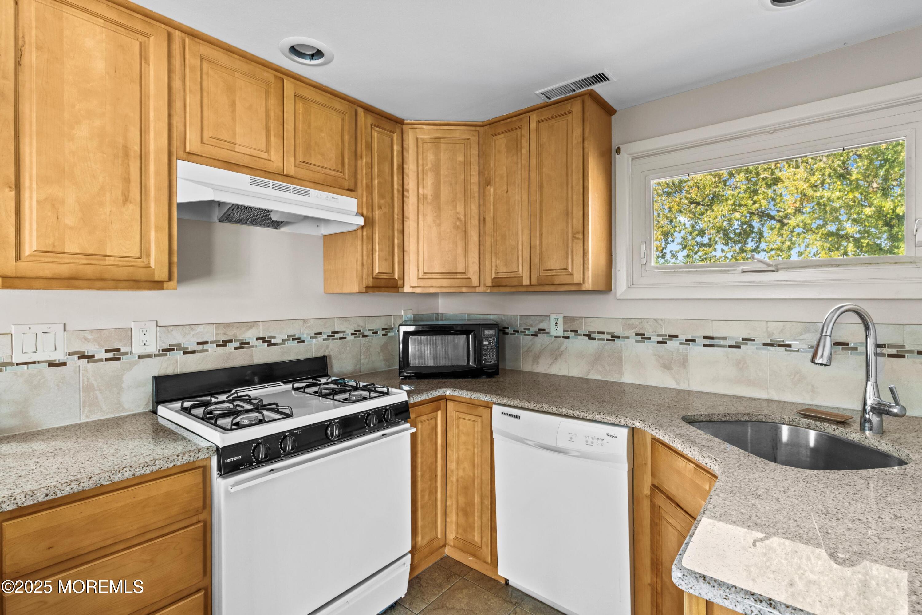 633 North Manetta Drive Point Pleasant, NJ 08742 - Photo 8 of 28 a kitchen with granite countertop a sink stove and cabinets