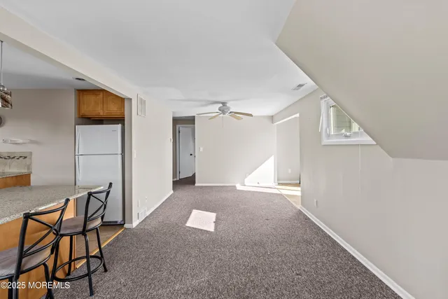 a view of a livingroom with furniture and a ceiling fan