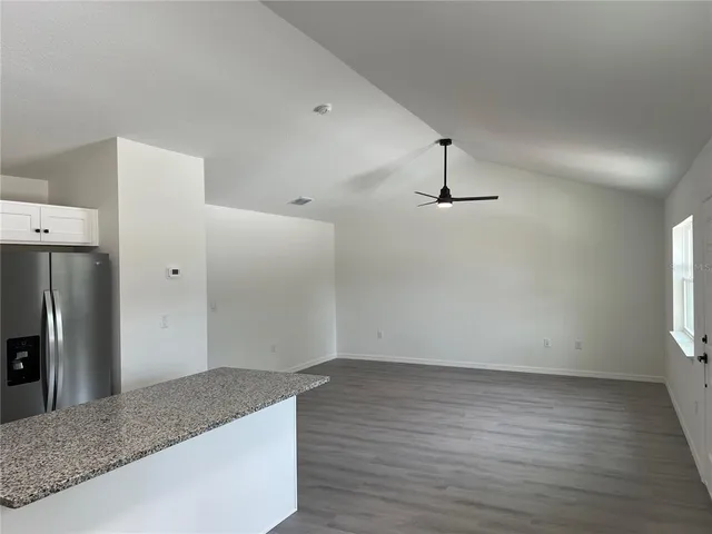 a view of a kitchen with refrigerator and window