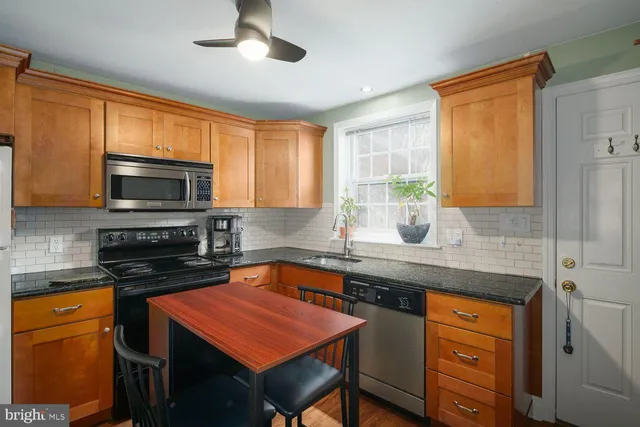 a kitchen with stainless steel appliances granite countertop microwave stove top oven and cabinets