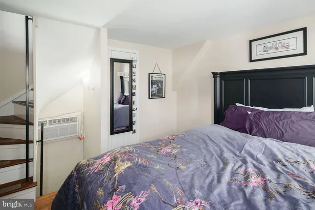 a bedroom with a large bed and paintings on the wall