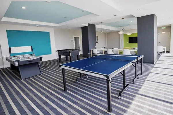 a living room with a table chairs and a wooden floor