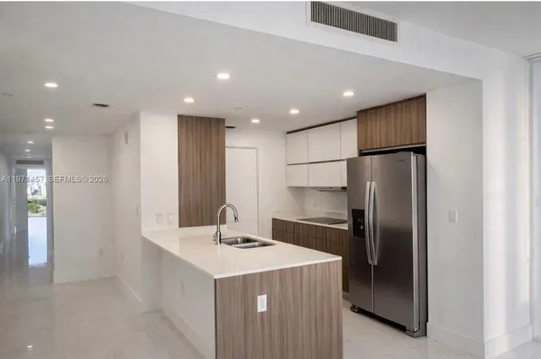 a kitchen with kitchen island a refrigerator sink and microwave