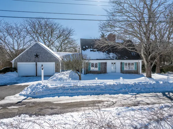 a view of a house with a yard and large tree