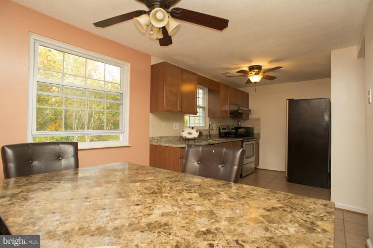 6224 Hillside Road Springfield, VA 22152 - Photo 3 of 8 a kitchen with kitchen island a counter top space appliances and a chandelier