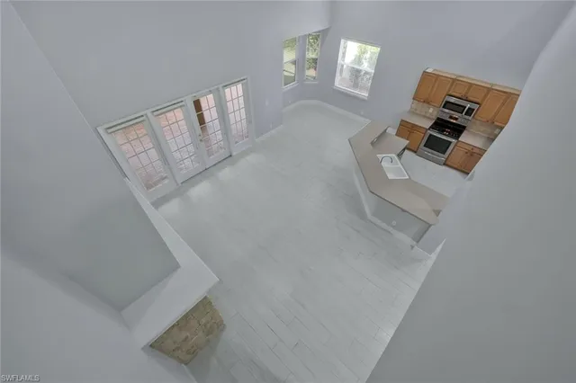 an empty room with windows and ceiling fan