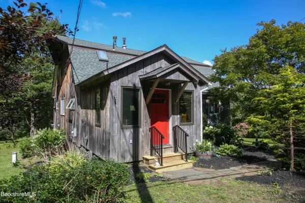 a view of small house with yard and plants