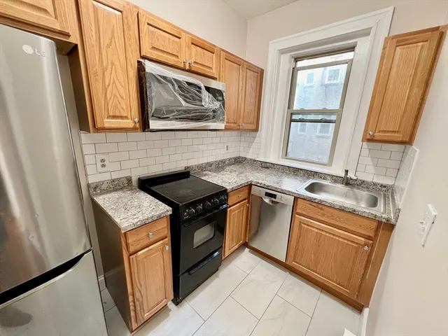 a kitchen with granite countertop a sink stove and cabinets