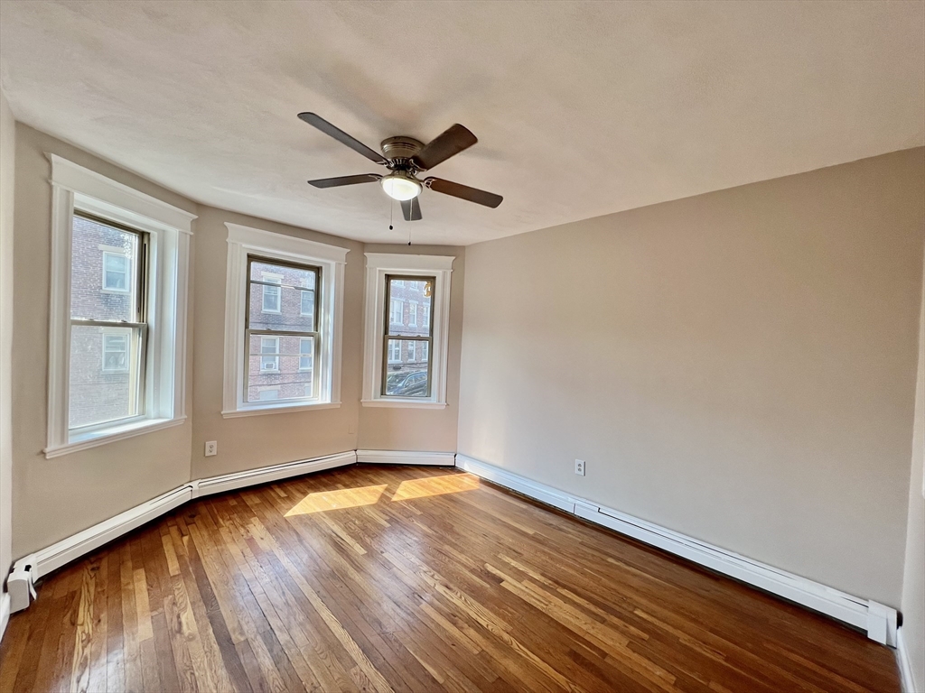 1669 Commonwealth Avenue, Unit 3 Boston, MA 02135 - Photo 6 of 10 a view of empty room with wooden floor and fan