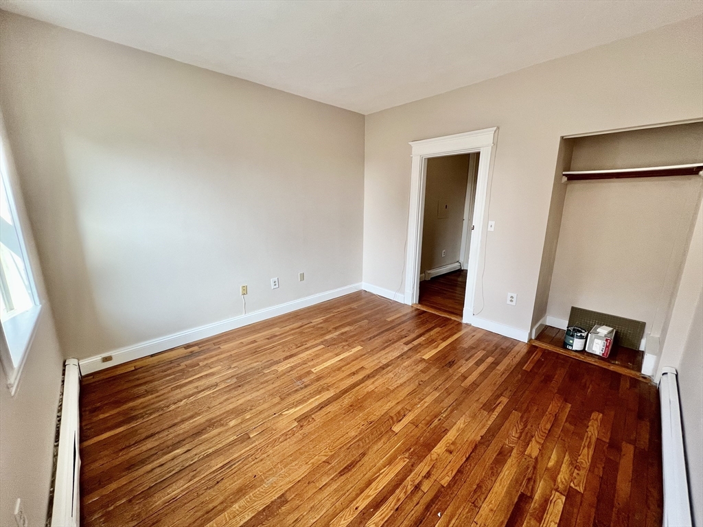 1669 Commonwealth Avenue, Unit 3 Boston, MA 02135 - Photo 8 of 10 a bedroom with a bed and wooden floor