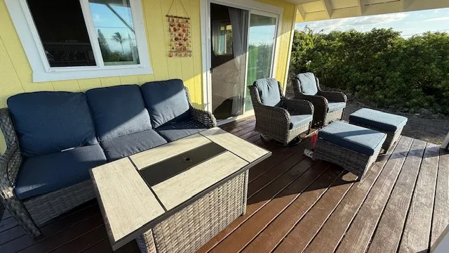 a balcony with wooden floor table and chairs