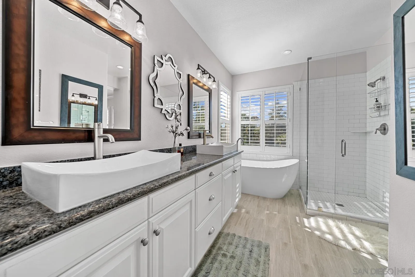 558 Beach Street Encinitas, CA 92024 - Photo 24 of 29 a spacious bathroom with a double vanity sink a mirror and a bathtub