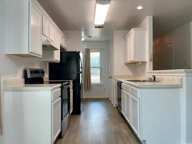 a kitchen with stainless steel appliances a stove refrigerator sink and cabinets