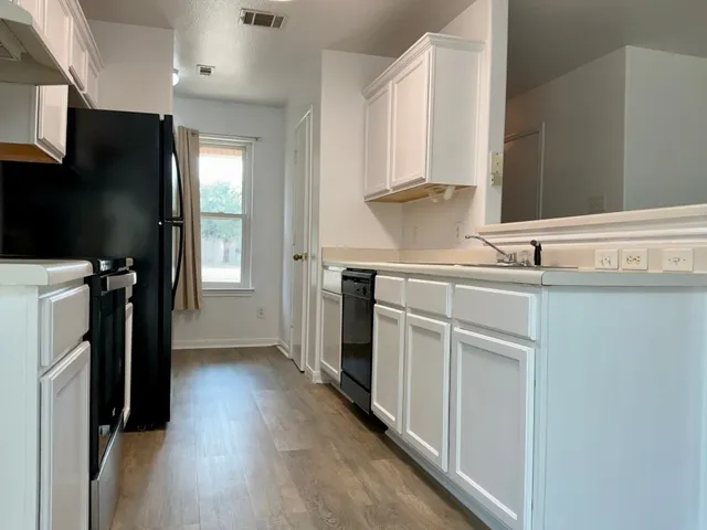 a kitchen with a sink appliances and cabinets