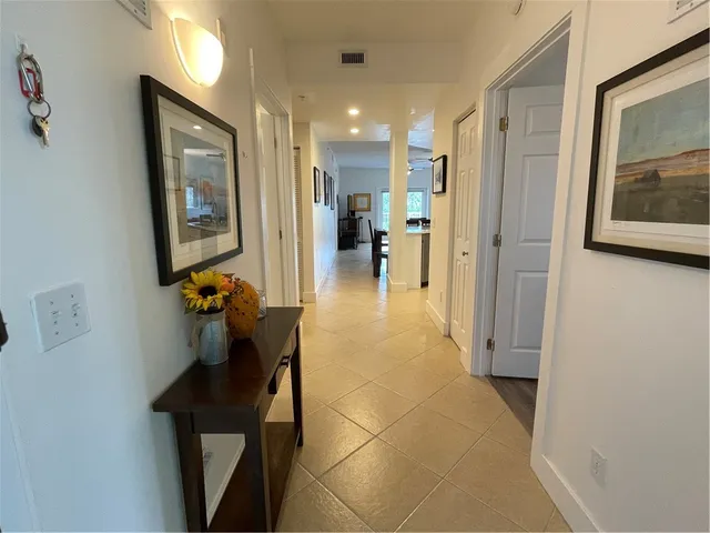 a view of hallway with furniture and a chandelier