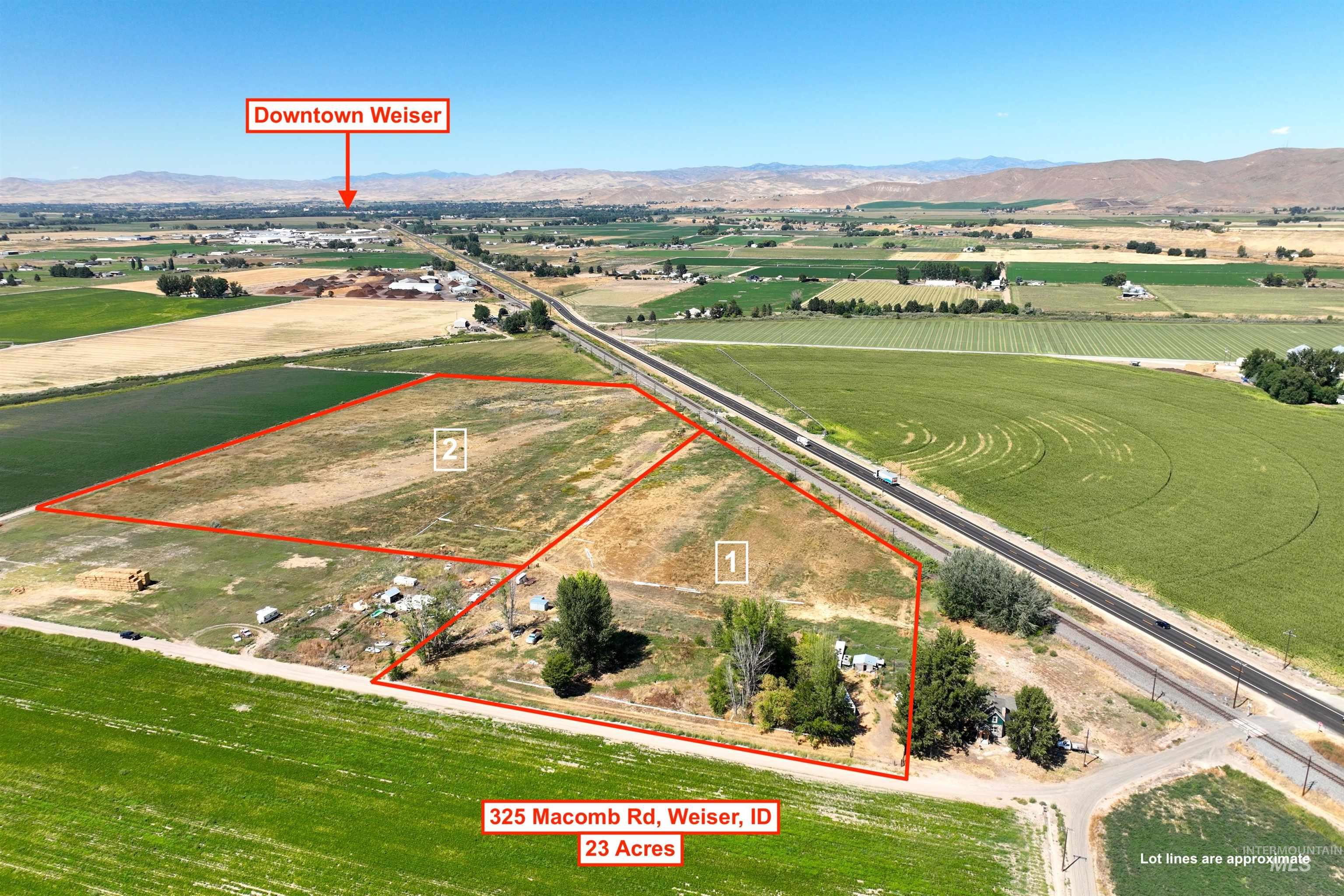 View of rural area with mountains, property parcel outlined, and large plots for crops