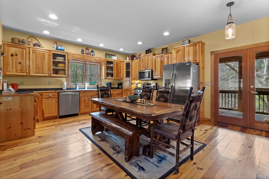 40 Graham Court Ellijay, GA 30540 - Photo 11 of 62 a open kitchen with stainless steel appliances granite countertop a stove top oven a sink dishwasher a dining table and chairs with wooden floor