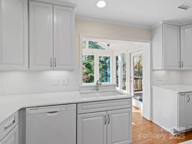 a kitchen with granite countertop white cabinets and stainless steel appliances