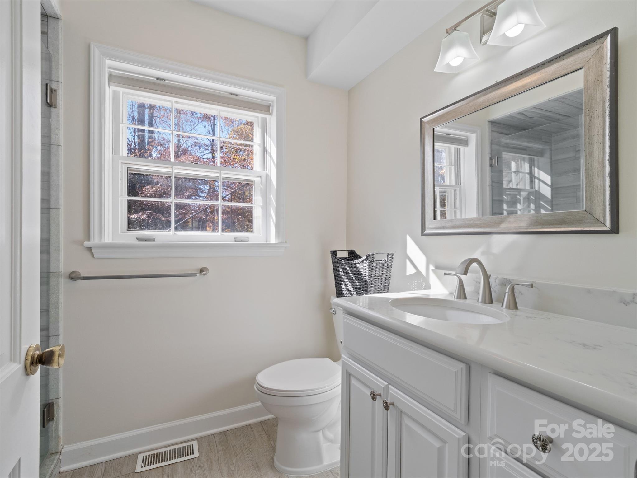 2111 Sagamore Road Charlotte, NC 28209 - Photo 37 of 48 a bathroom with a toilet a sink a vanity and mirror