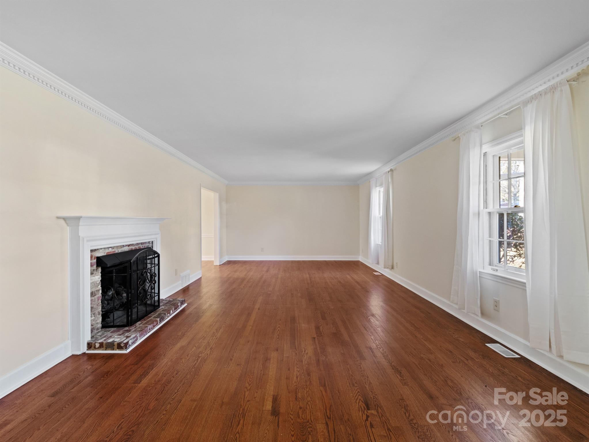 2111 Sagamore Road Charlotte, NC 28209 - Photo 8 of 48 an empty room with wooden floor fireplace and windows