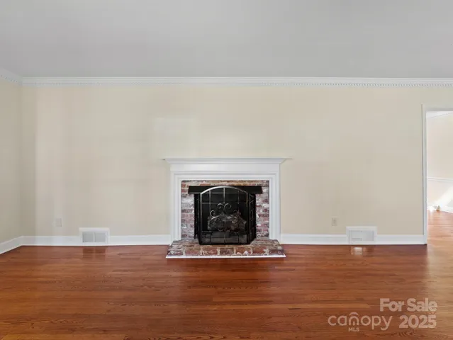 a view of a livingroom with wooden floor and a fireplace