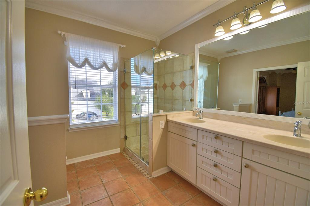 908 Yew Court Celebration, FL 34747 - Photo 42 of 78 a spacious bathroom with a double vanity sink a large mirror and a shower
