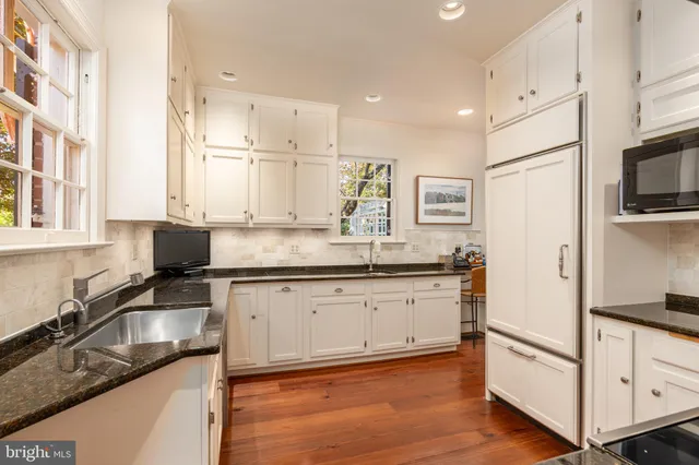a kitchen with granite countertop white cabinets and white appliances