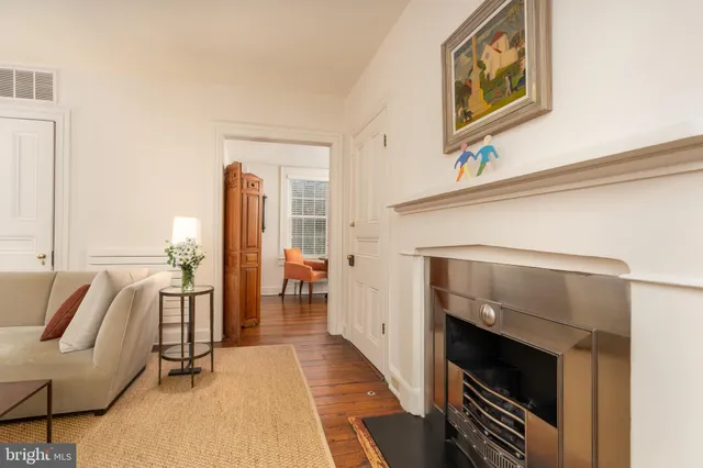 a living room with furniture a fireplace and next to a window