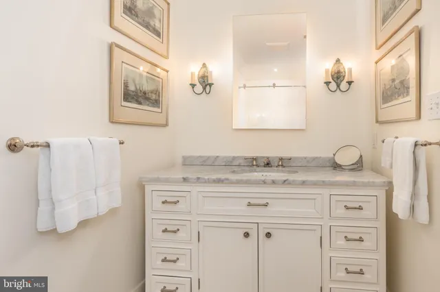 a bathroom with a granite countertop sink vanity mirror and