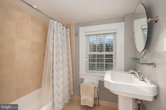 a bathroom with a sink a mirror and a window