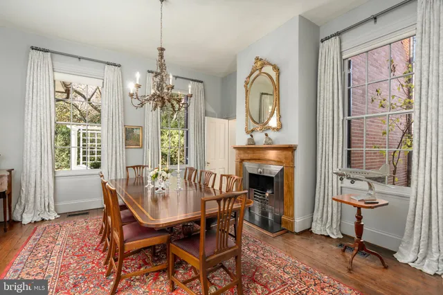 a dining room with furniture a fireplace and wooden floor