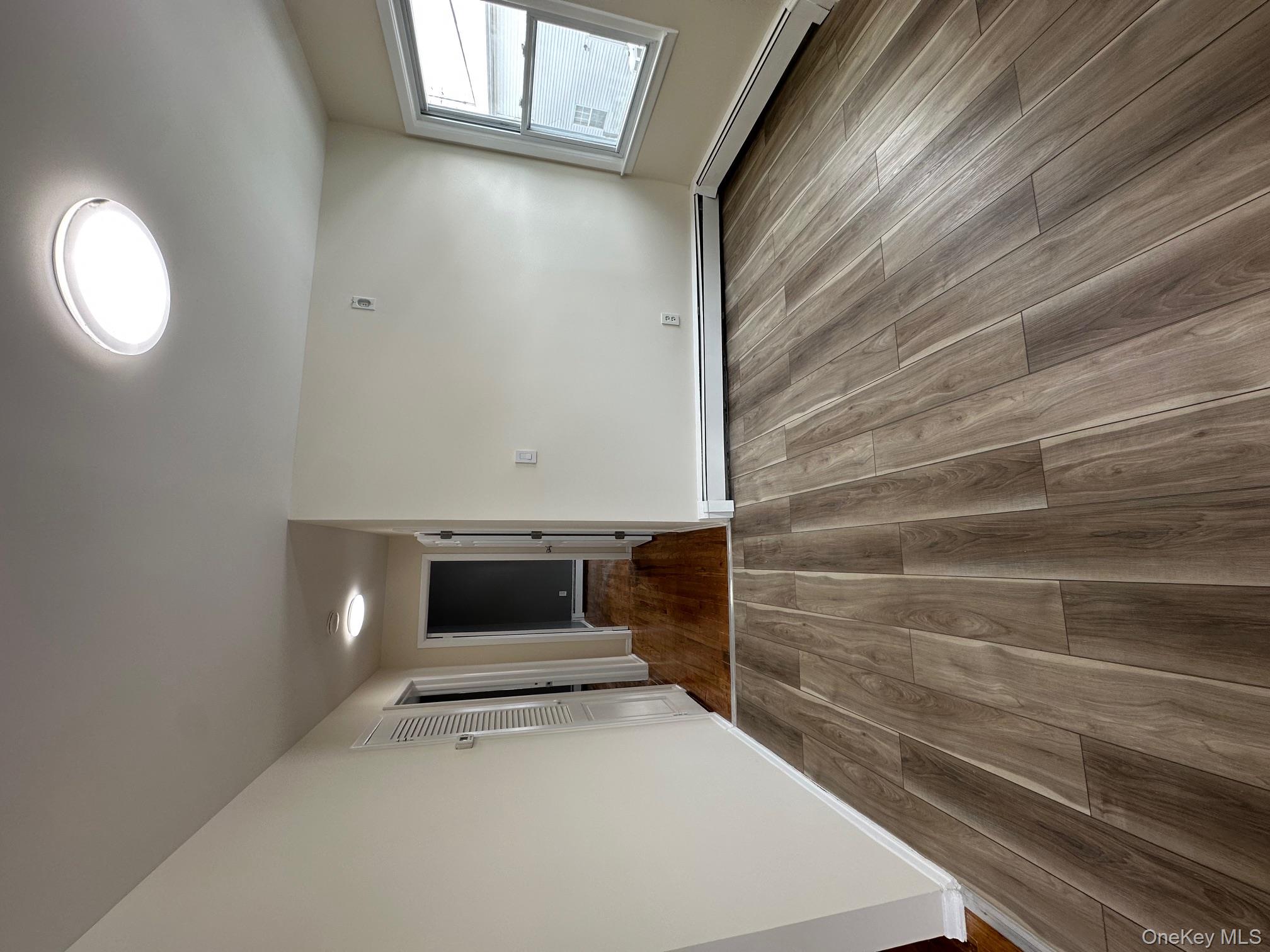 25 Concord Street Lynbrook, NY 11563 - Photo 4 of 11 wooden floor in an empty room with a window
