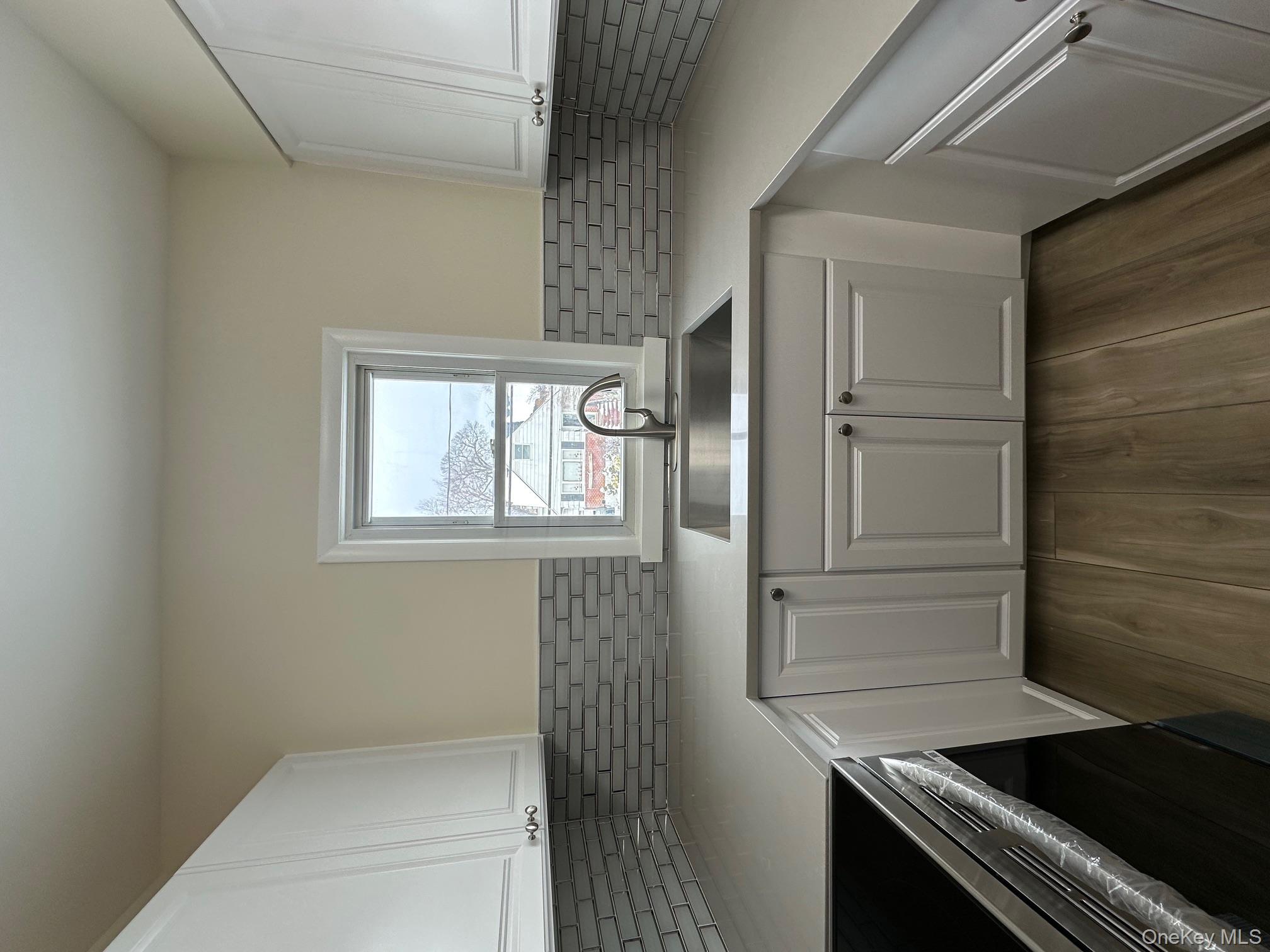 25 Concord Street Lynbrook, NY 11563 - Photo 5 of 11 a kitchen with sink cabinets and window