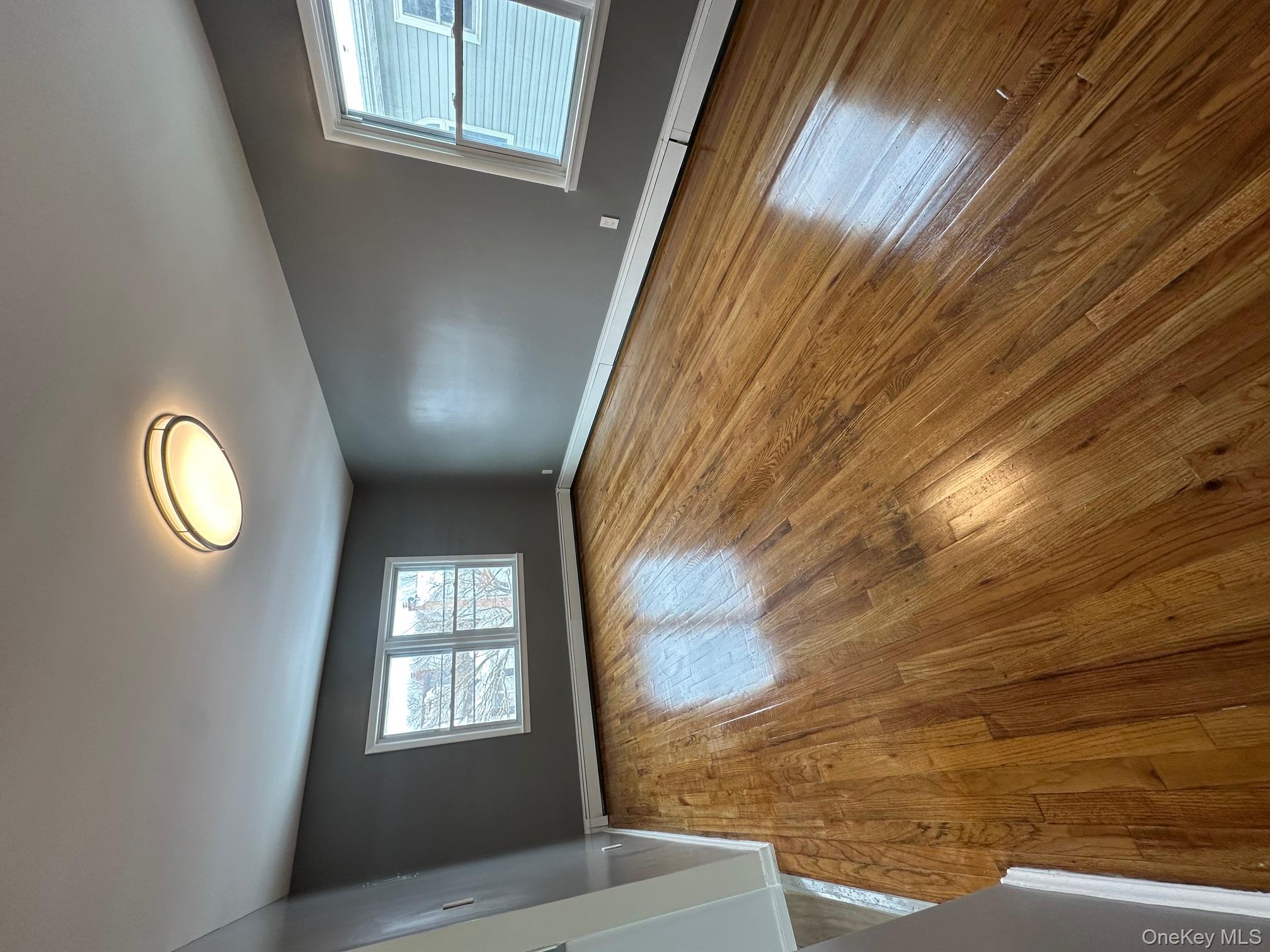 25 Concord Street Lynbrook, NY 11563 - Photo 9 of 11 wooden floor in an empty room with a window