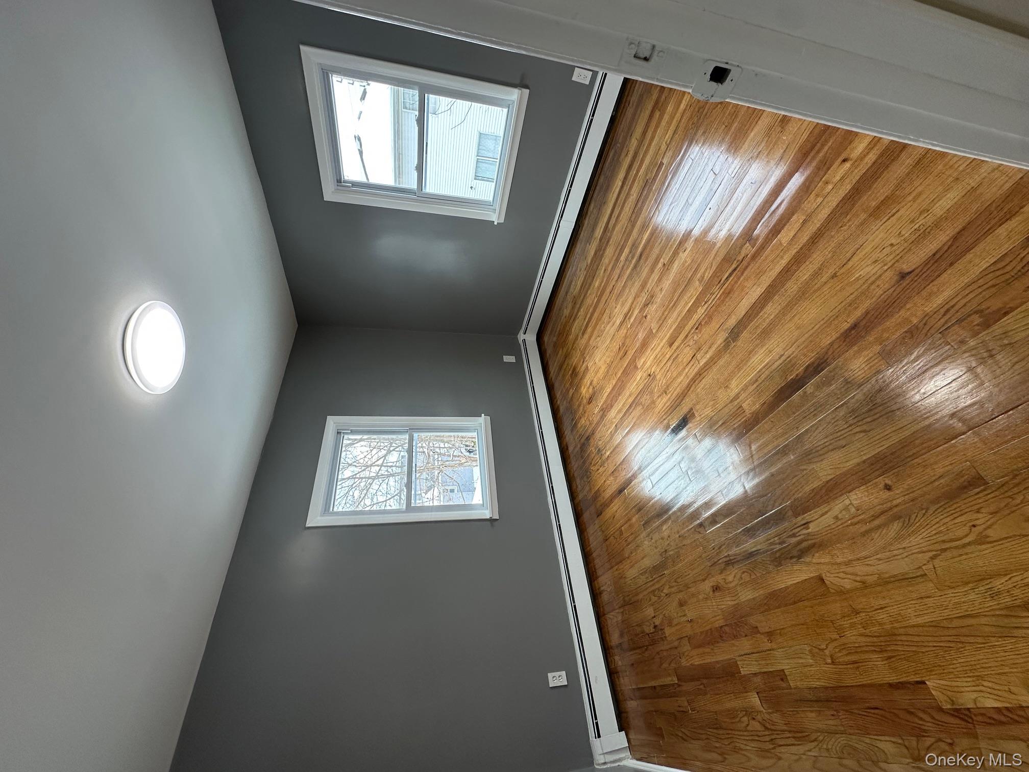 25 Concord Street Lynbrook, NY 11563 - Photo 10 of 11 a view of an empty room with wooden floor and a window