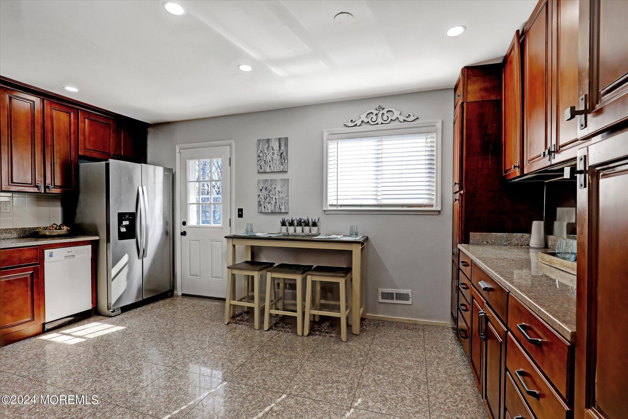 27 Chestnut Ridge Road Holmdel, NJ 07733 - Photo 3 of 35 a kitchen with stainless steel appliances granite countertop a refrigerator a stove a sink a dining table and chairs