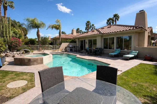 a view of a house with swimming pool and sitting area