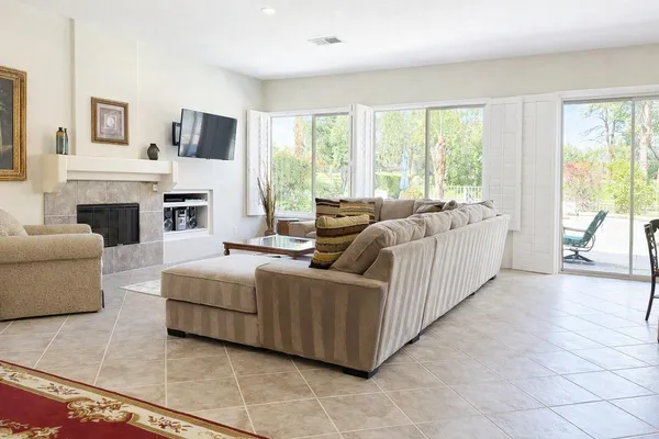 a living room with furniture a flat screen tv and a fireplace