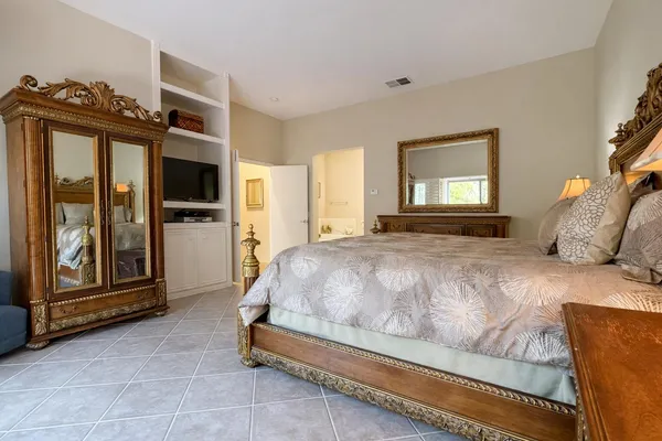 a spacious bedroom with a bed and wooden floor