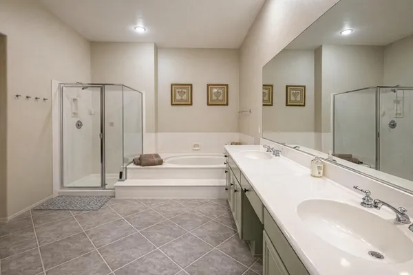 a spacious bathroom with a tub sink and mirror